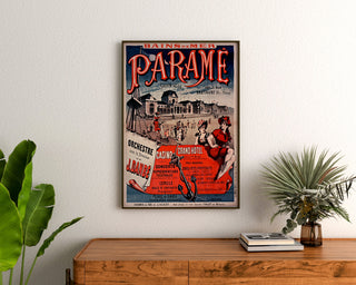 Wydruk plakatowy Bretania vintage – Paramé, zatoka Saint-Malo, oprawiony nad drewnianą komodą, między roślinami.