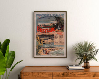 Wintage plakat Bretania – Plages de Bretagne, koleje, w ramie nad drewnianą komodą, między roślinami.