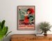 Retro plakat reklamowy Champagne Damery-Épernay, oprawiony nad drewnianą komodą, między roślinami.