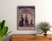 Plakat reklamowy vintage Galeries sedanaises, Nouveautés, oprawiony nad drewnianą komodą, między roślinami.