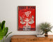 Retro plakat reklamowy Paris–Dijon, zabawki i noworoczne prezenty, oprawiony nad drewnianą komodą, między roślinami.