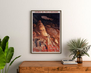Wintage plakat turystyczny – Grottes de Lacave, Rocamadour, w ramie nad drewnianą komodą, między roślinami.