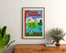 Turystyczny plakat vintage – L’Ain touristique, oprawiony nad drewnianą komodą, między roślinami.