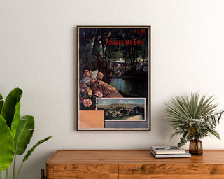 Plakat turystyczny vintage – Pougues-les-Eaux, PLM, oprawiony nad drewnianą komodą, między roślinami.