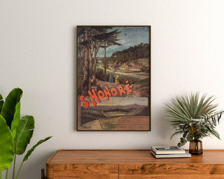 Plakat turystyczny vintage – Saint-Honoré-les-Bains, PLM, oprawiony nad drewnianą komodą, między roślinami.