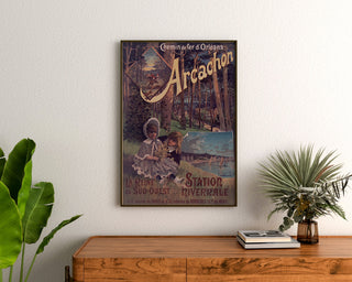 Wintage plakat Arcachon, stacja zimowa, oprawiony nad drewnianą komodą, między roślinami.