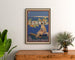 Plakat vintage Cannes, Les Sports élégants, oprawiony nad drewnianą komodą, między roślinami.