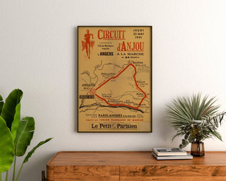 Plakat vintage Circuit d’Anjou, piesza wycieczka, w ramie nad drewnianą komodą, między roślinami.