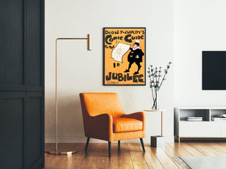 Plakat vintage Dudley Hardy, comic guide, oprawiony w salonie z pomarańczowym fotelem i lampą stojącą.
