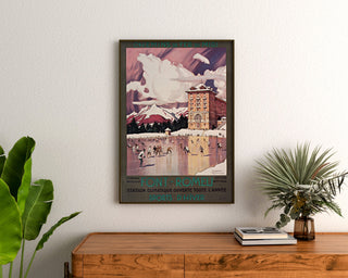 Plakat vintage Font-Romeu, sporty zimowe, w ramie nad drewnianą komodą, między roślinami.