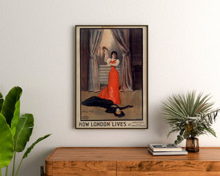 Plakat vintage How London Lives, Surrey Theatre, oprawiony nad komodą z drewna, między roślinami.