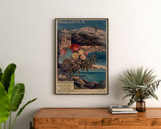 Plakat vintage La Turbie, koleje PLM, oprawiony nad drewnianą komodą, między roślinami.