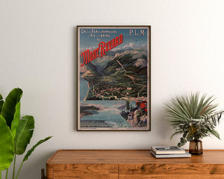 Plakat vintage Mont-Revard, zębatkowa kolejka, oprawiony nad drewnianą komodą, między roślinami.