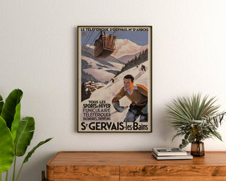 Plakat vintage Saint-Gervais, Mont-d’Arbois, oprawiony nad drewnianą komodą, między roślinami.