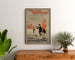 Plakat vintage Two Little Vagabonds, oprawiony nad drewnianą komodą, między roślinami.
